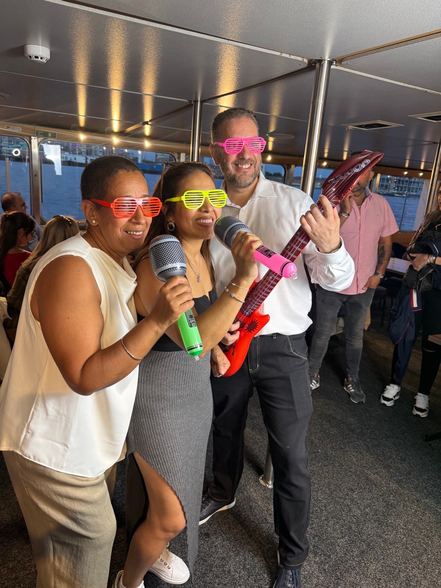 Guests laughing with inflatable party props at a PhotoGenieBooths photo booth