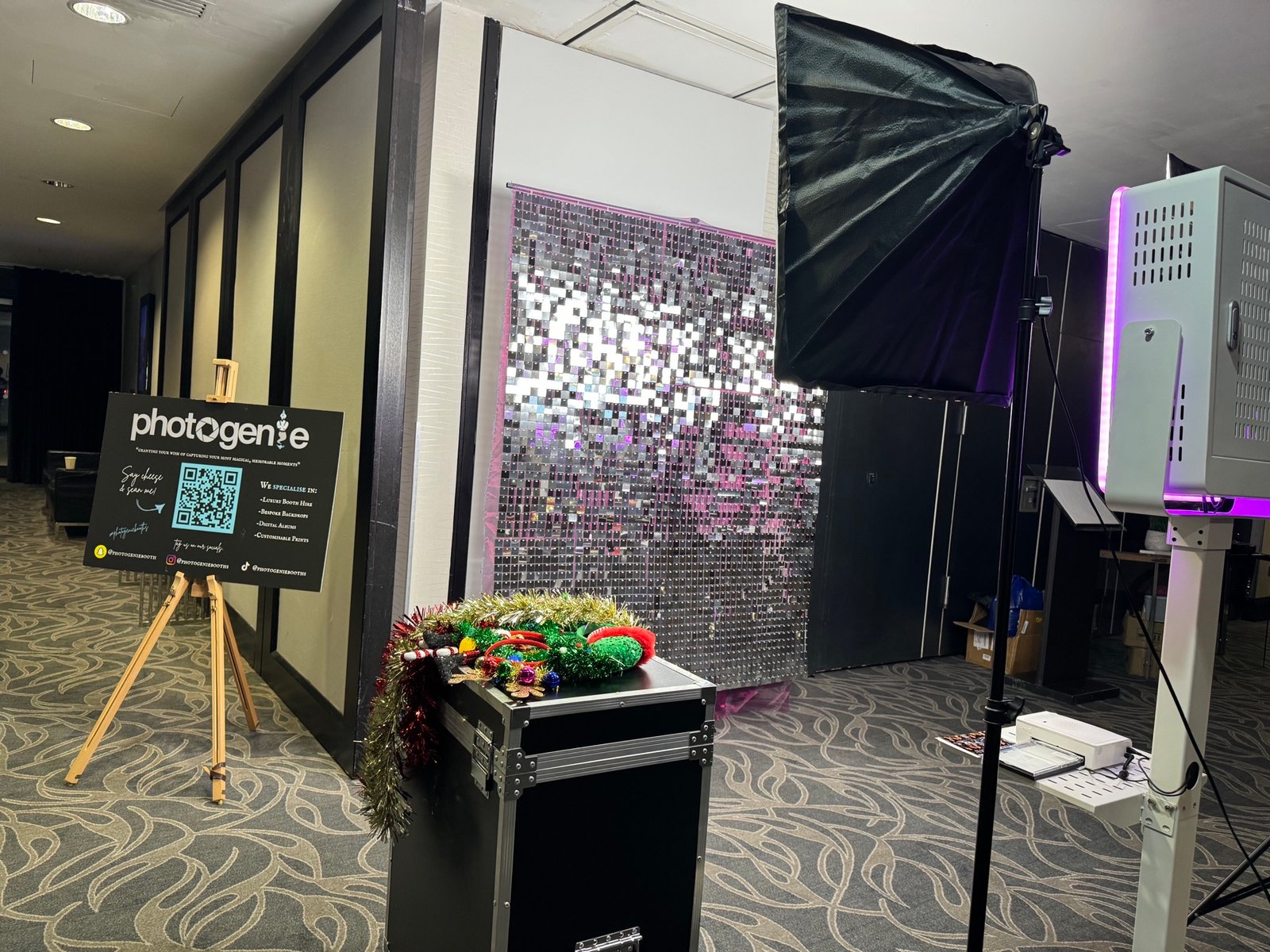 PhotoGenieBooths set up with a silver sequin backdrop and purple LED lighting at an indoor event
